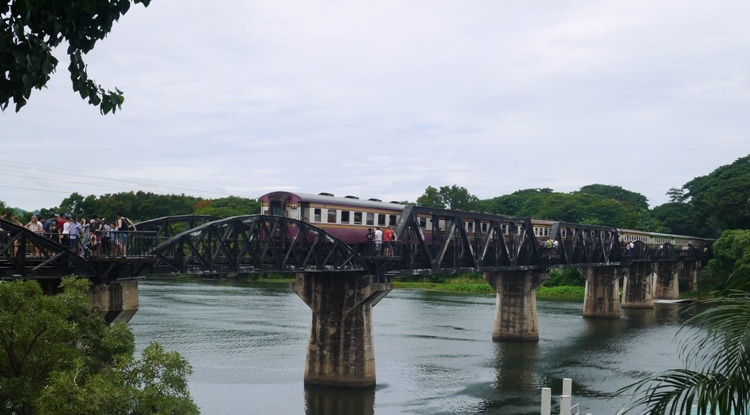 Train Crossing The River Kwai Bridge In Kanchanaburi, Thailand