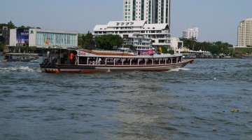 An Express Boat Traveling Along The Chao Phraya River In Bangkok