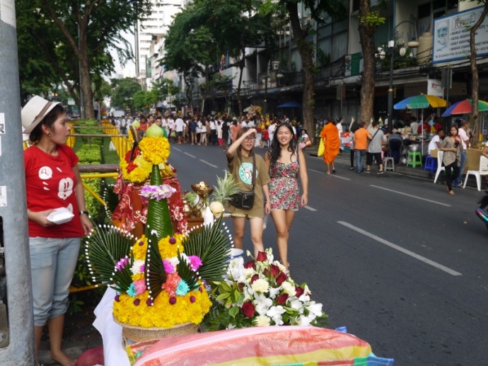 Two Girls Walk Passed A Shrine On Silom Road