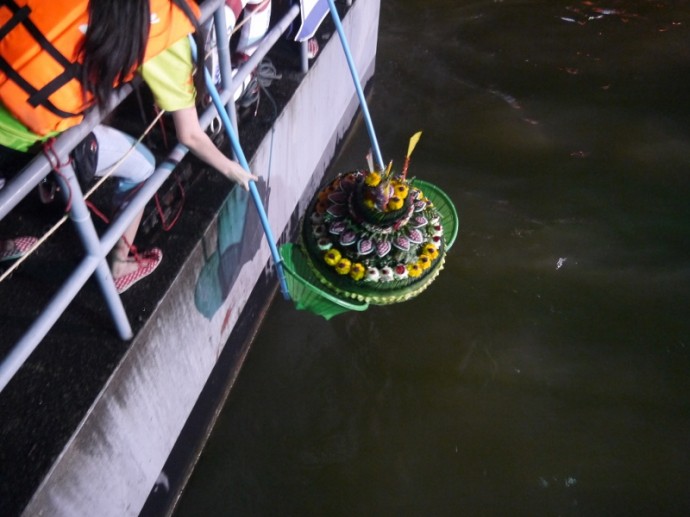 A Large Krathong Being Lowered Into The River A Large Krathong Being Lowered Into The River